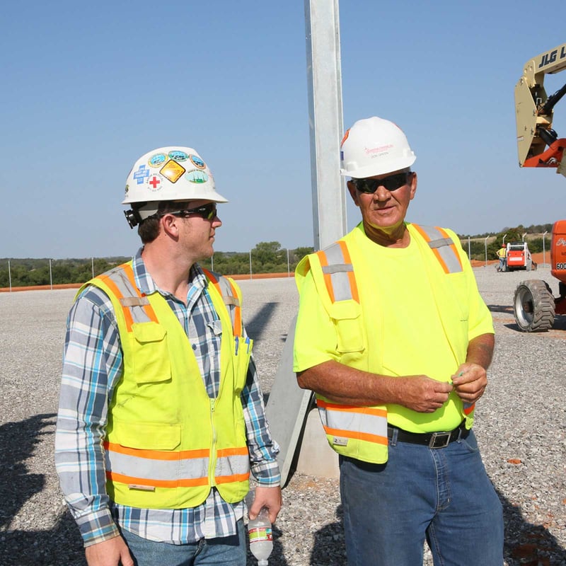 A man wearing a bright yellow safety vest stands confidently, showcasing his commitment to safety and visibility