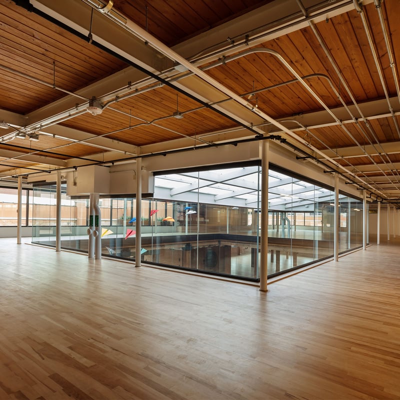 An empty office featuring wooden floors and glass walls