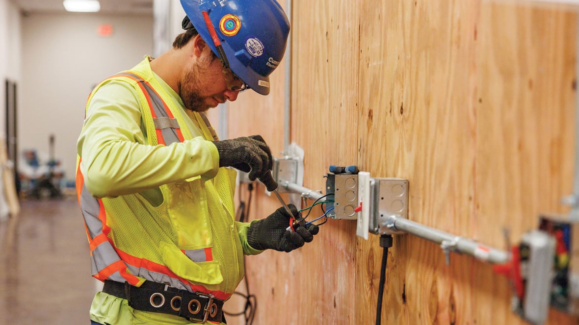 electrician working on switches and outlets at a job site