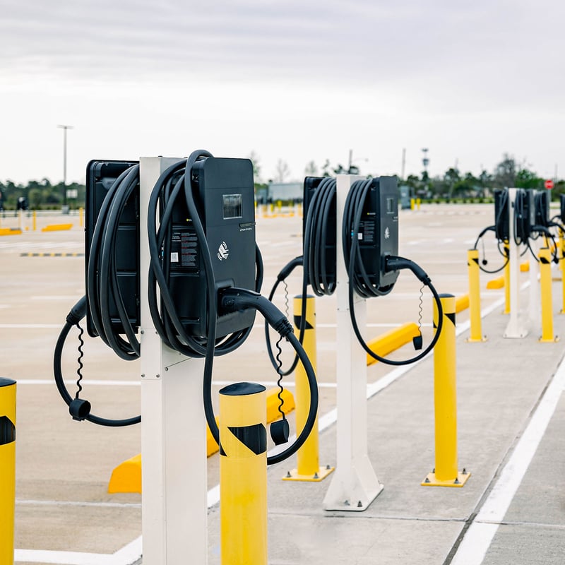 multiple EV chargers lines up in a parking lot