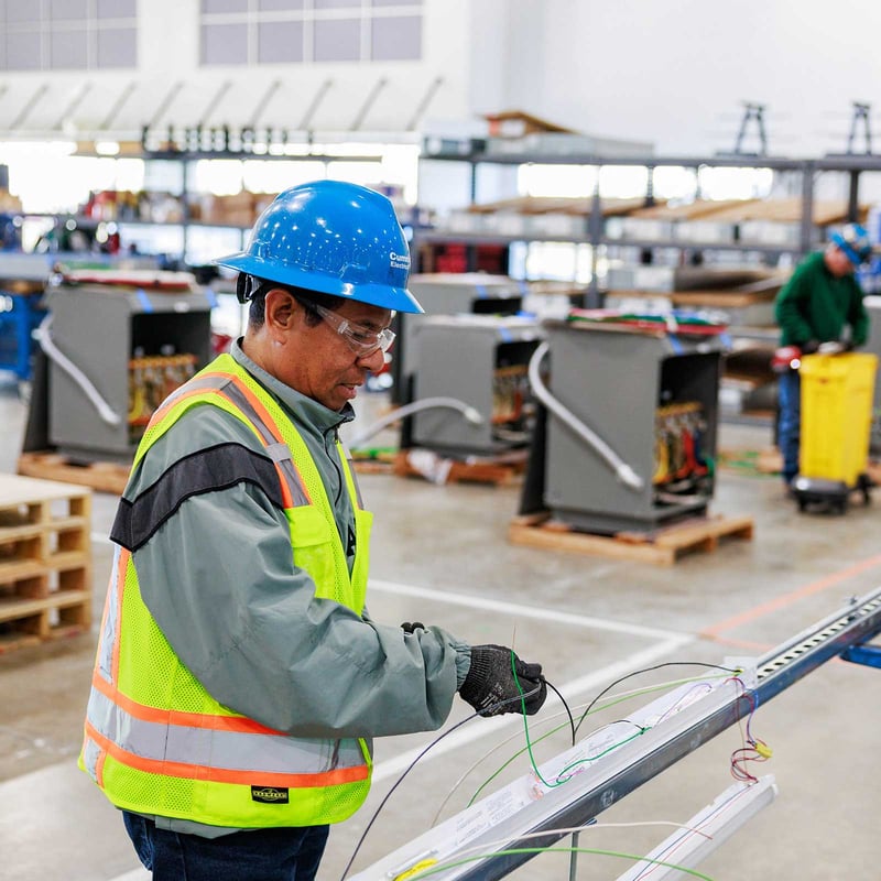 Cummings technician working in a warehouse with prefabricated electrical equipment