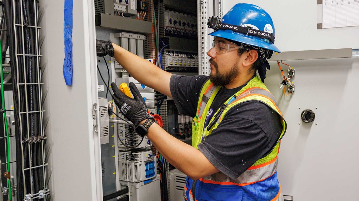 An electrician working on a fuse box