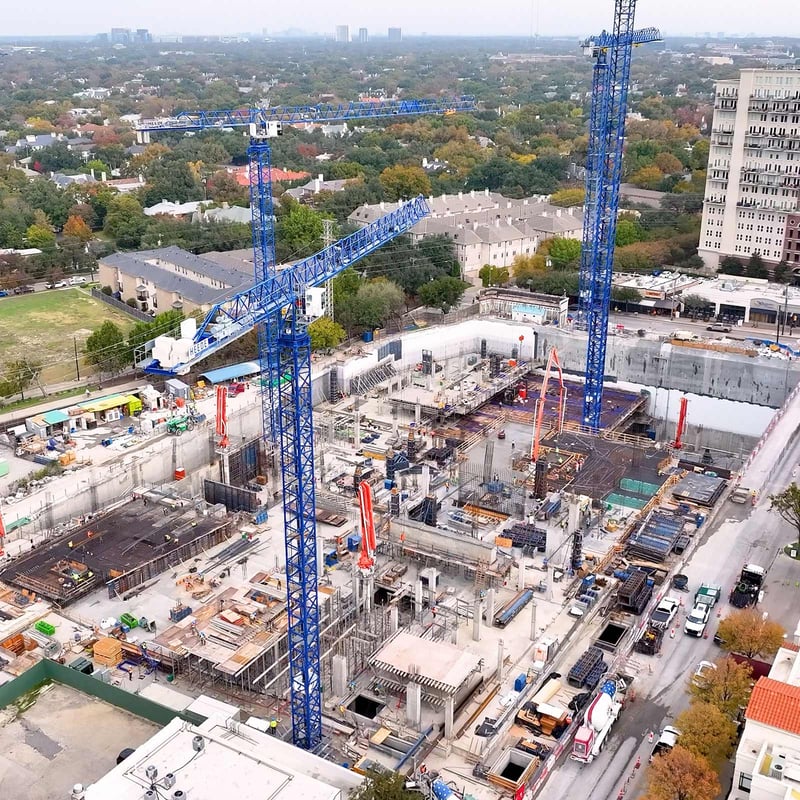 Aerial view of a ground-up construction site with multiple cranes surrounding multi-family communities