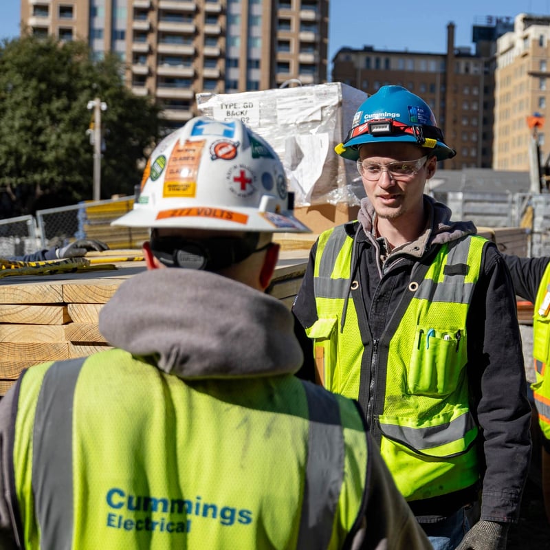 Cummings team members wearing hard hats and safety vests while outdoors at a job site