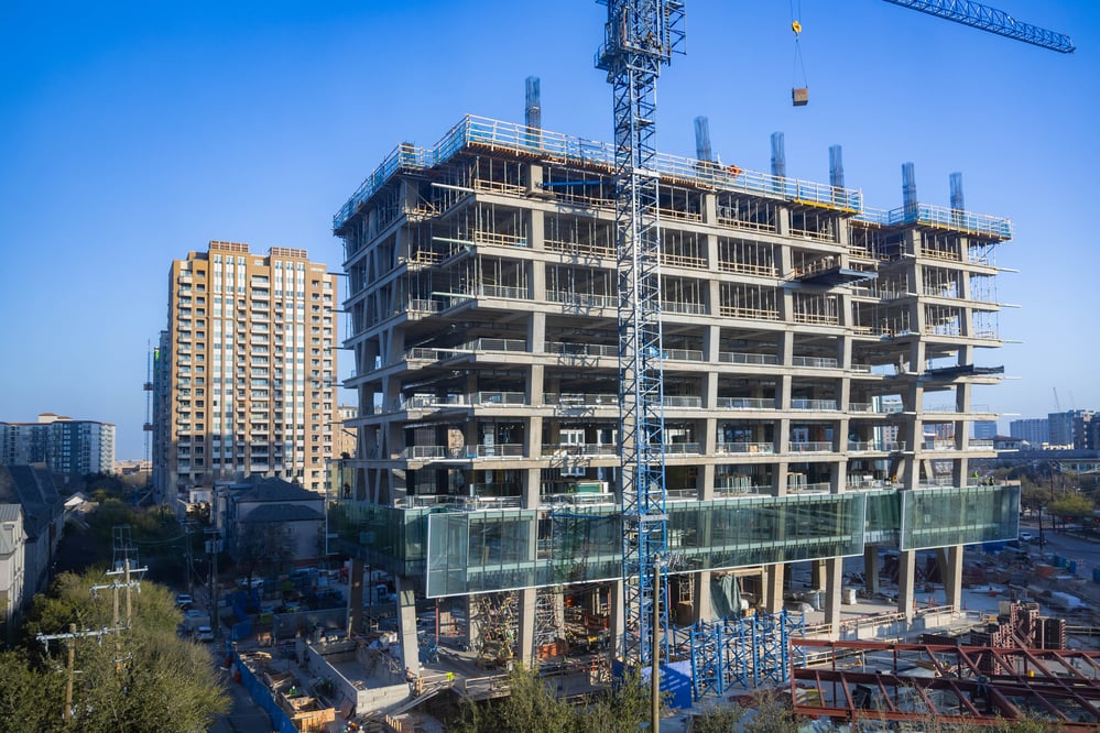 construction of a building in a dense downtown setting with cranes.