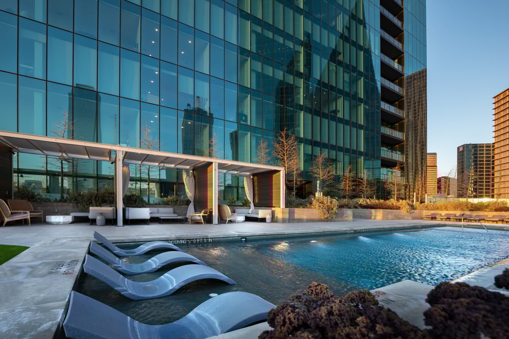 Poolside view next to a modern glass high-rise building in a downtown area