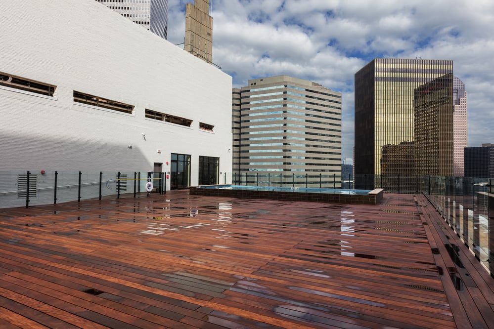 Rooftop view of a small pool surrounded by multiple high-rise buildings