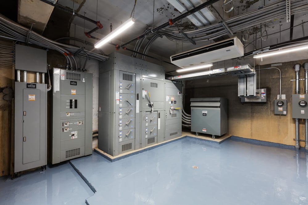 Electrical room with panels and conduit spanning the ceiling 