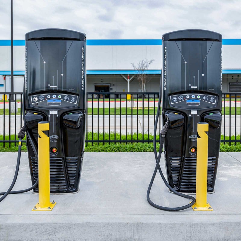 Couple of electric vehicle chargers next to each other outside of a warehouse