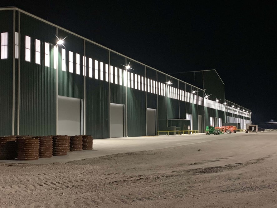 nighttime view of an industrial facility with lighting surrounding the building
