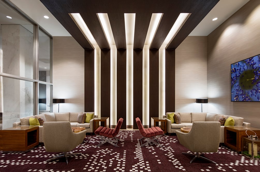 Modern hotel lobby with rows of lighting spanning from the wall to ceiling