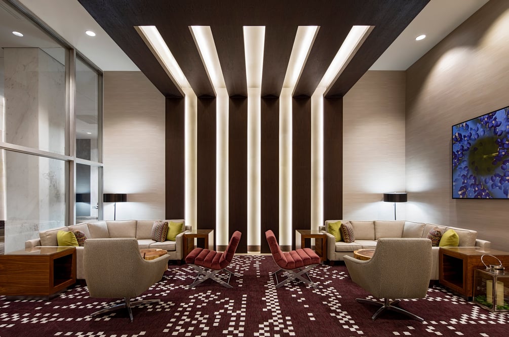 Modern hotel lobby with rows of lighting spanning from the wall to ceiling