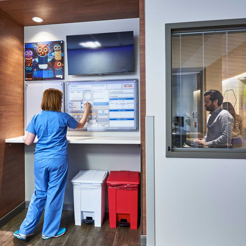 Methodist hospital office area with staff working at computer and writing on a status board