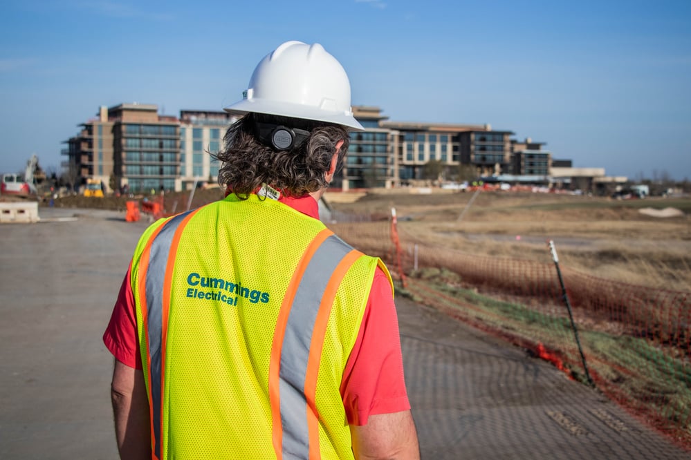 Cummings Technician walking towards a building in active construction