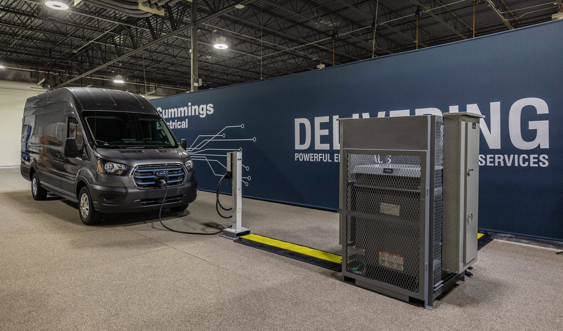 Interview view of an EV delivery van hooked into a charger connected to a prefabricated electrical skid