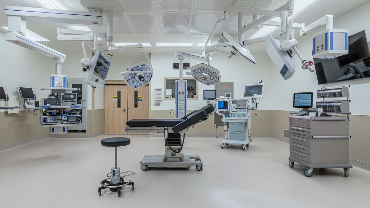 Sterile hospital operating room with ceiling-mounted equipment and surgical lights